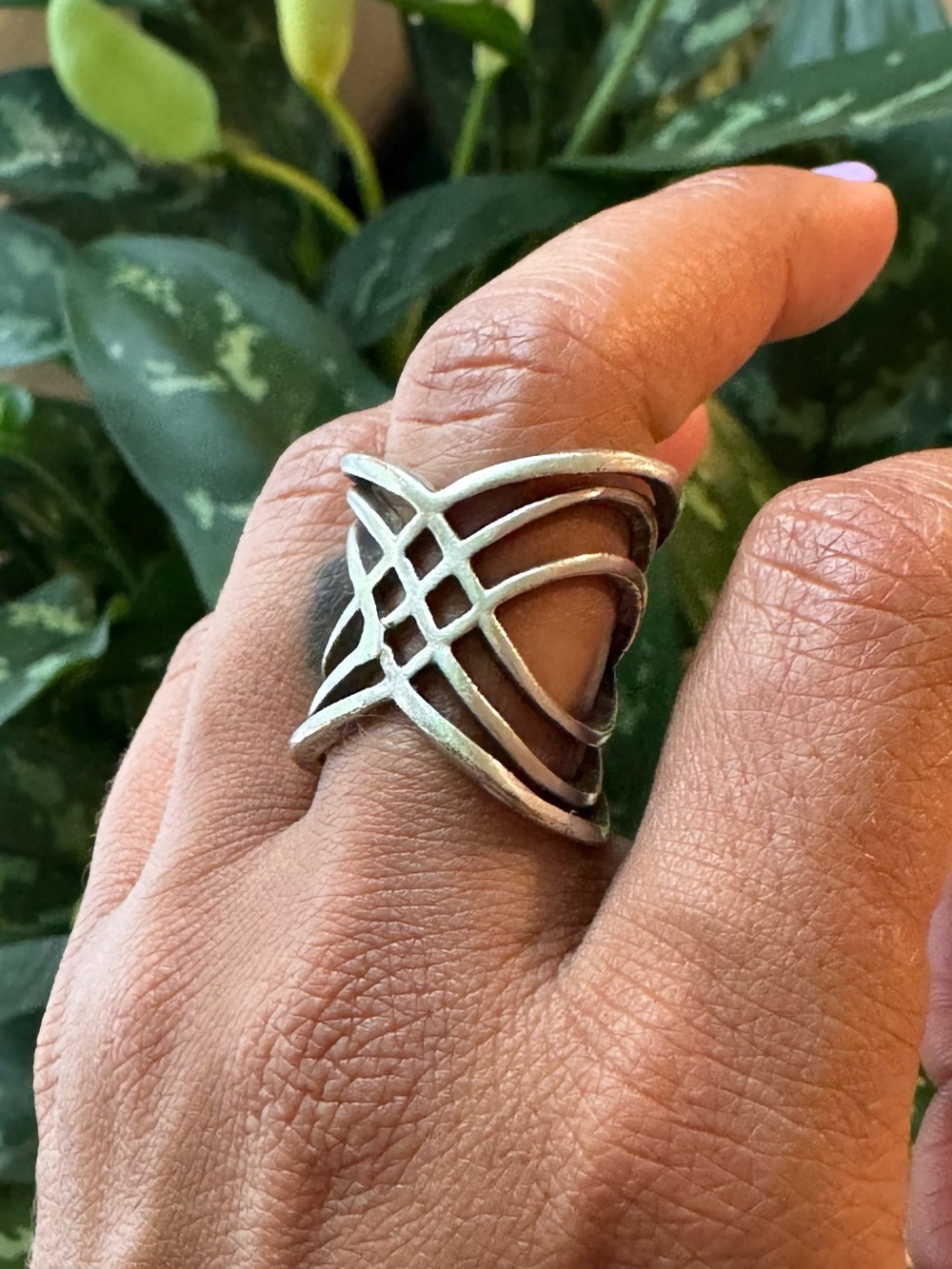 Silver tone ring with unique interwoven design.